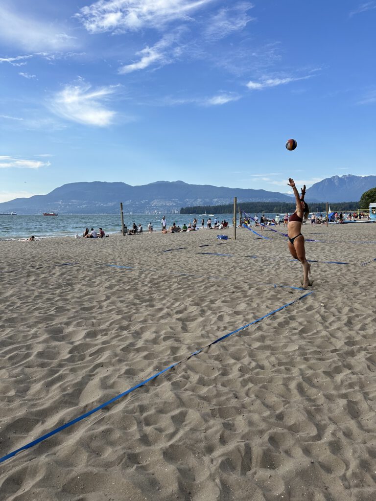 Beach volleyball player serving the ball during a match