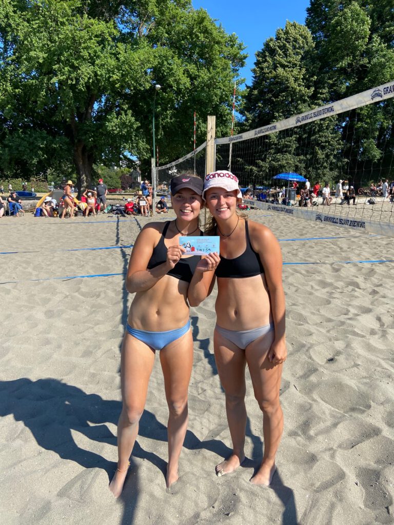 Beach volleyball team receiving prize money after an event win