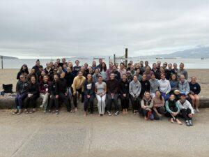 Group photo of Kitsilano Women's Volleyball Club members at Kitsilano beach