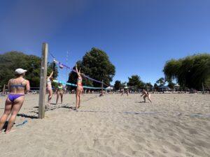 Women's beach volleyball athlete blocking another athlete hitting the ball